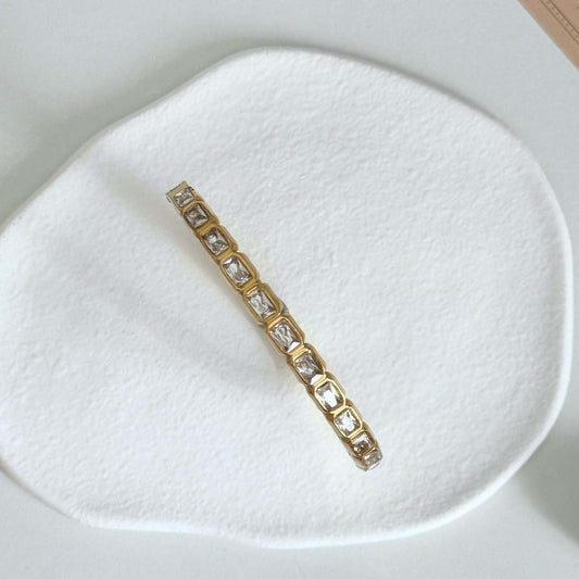 Veyra – Waterproof Gold Zircon Bangle with rectangular zircon stones on a textured surface.
