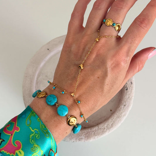 Gold Turquoise Bracelet displayed on a hand, showcasing vibrant turquoise stones and polished gold discs.