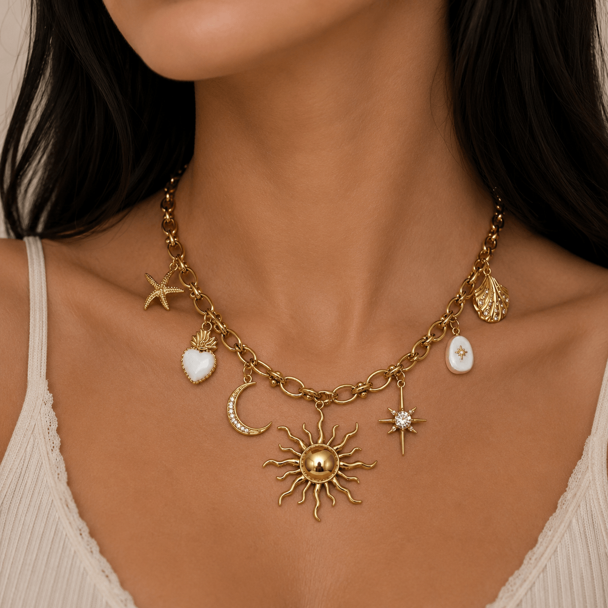 Gold charm necklace featuring sun, moon, star, shell, and heart charms, inspired by nature and the night sky.
