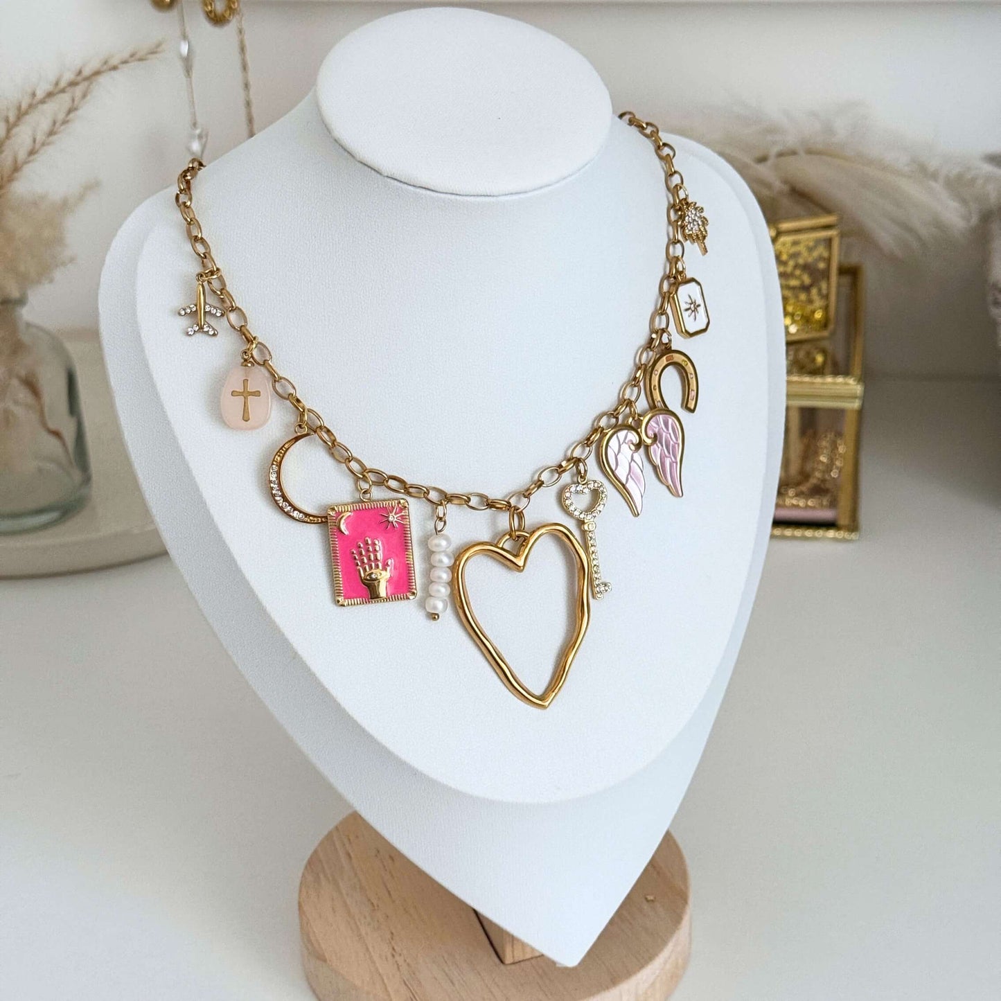Ariana Multi-Charm Necklace featuring various charms on a display bust in a stylish setting.