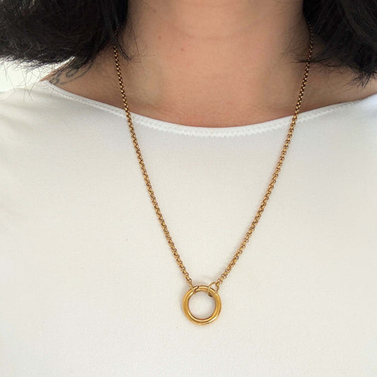 Carabiner charm necklace worn by a model, showcasing the elegant gold design on a white top.