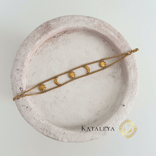 Celestial Harmony Bracelet displayed on a stone dish featuring sun and moon charms, showcasing its waterproof and tarnish-resistant design.