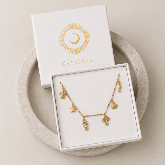Calista Ocean Charm Necklace displayed in a box, featuring gold coastal charms inspired by the ocean.