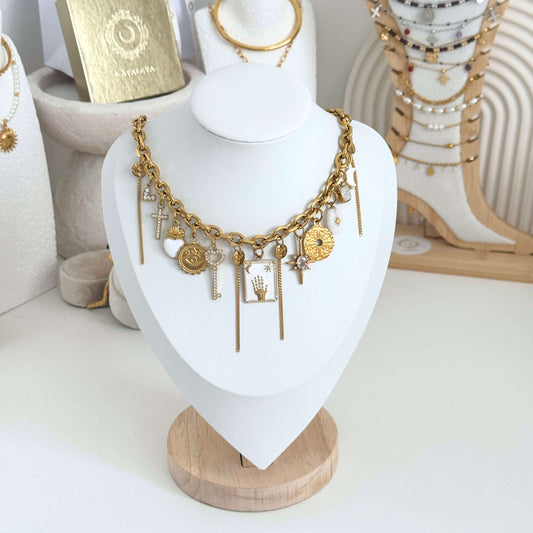 Gold necklace with charms on a white mannequin bust against a neutral background by Kataleya Jewellery