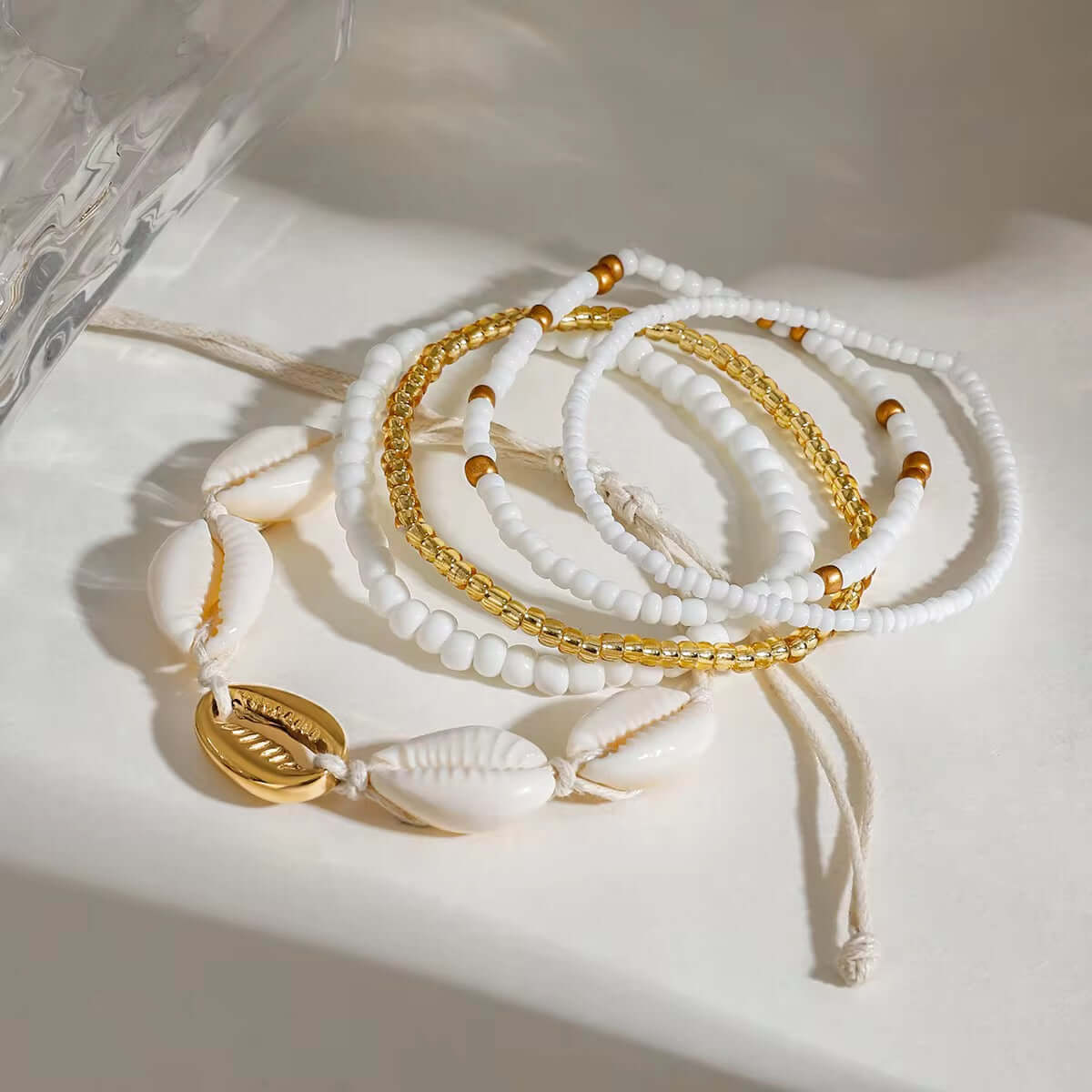 Set of Five white and gold beaded, shell bracelets on a string by Kataleya