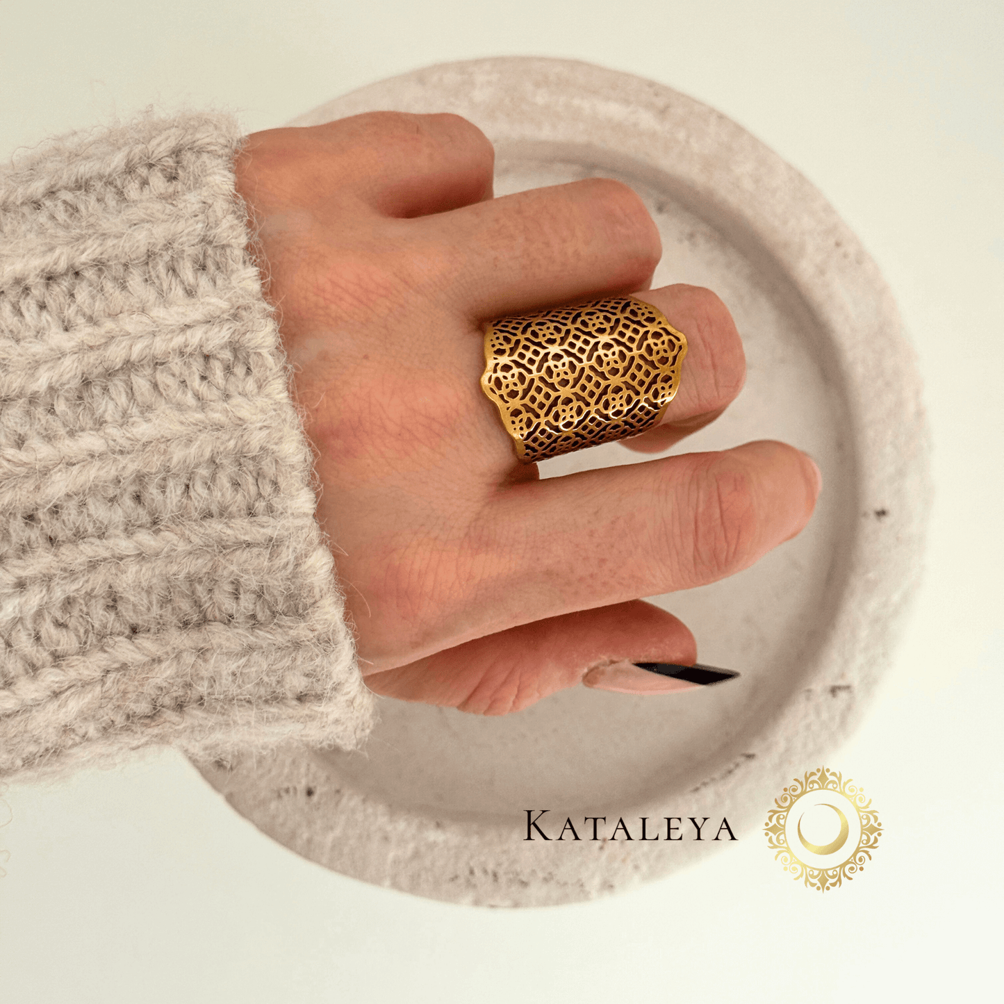Hand wearing a Statement Filigree Ring made of 18ct gold plated stainless steel on a neutral background.