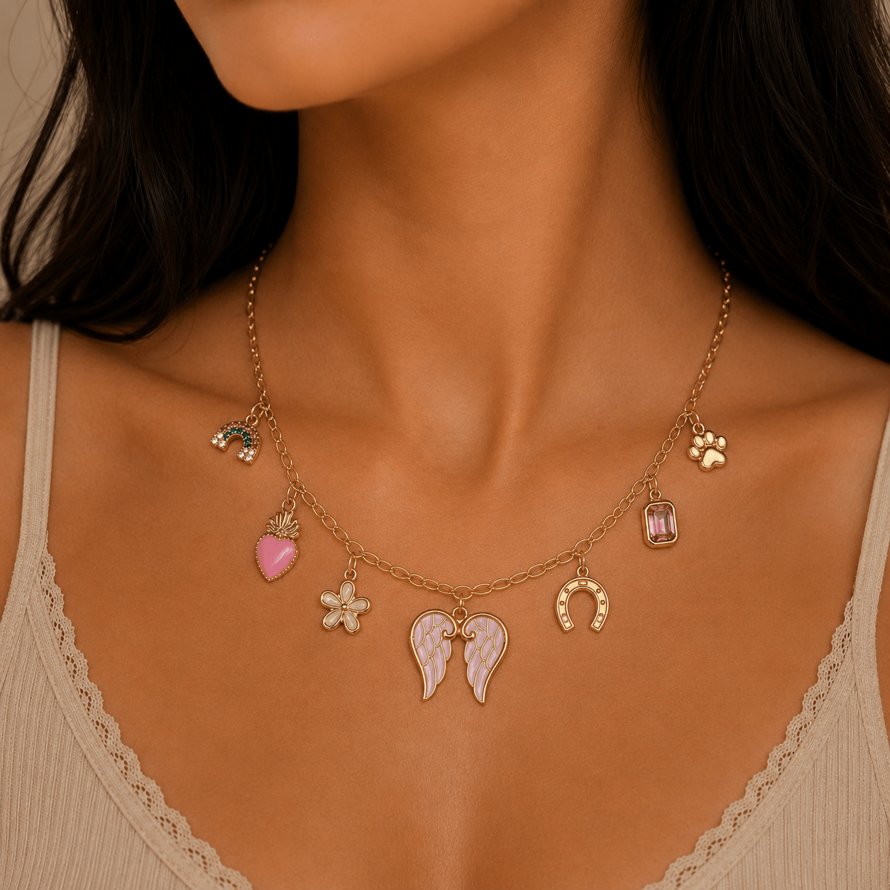 Iris Charm Necklace featuring gold and pink charms like angel wings, a sacred heart, and a horseshoe. Charm necklace.