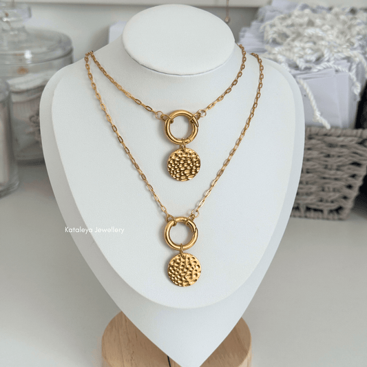 Coin Carabiner Necklace – Gold PVD Stainless Steel displayed on a necklace stand with textured coin pendant.