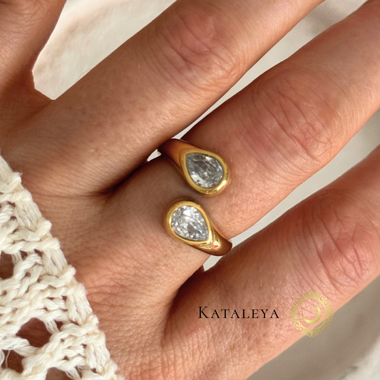 Twin Sparkle Wrap Ring showcasing two teardrop zircon stones in a sleek gold plated design on a hand.