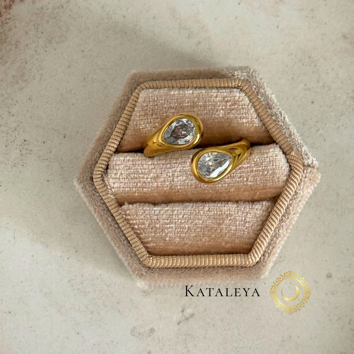 Twin Sparkle Wrap Ring displayed in hexagon ring holder with teardrop zircon stones and gold plating.