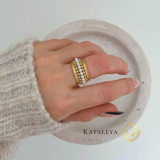 Aura Pearl Band Ring shown on a hand, featuring pearl accents and 18ct gold plated stainless steel band.