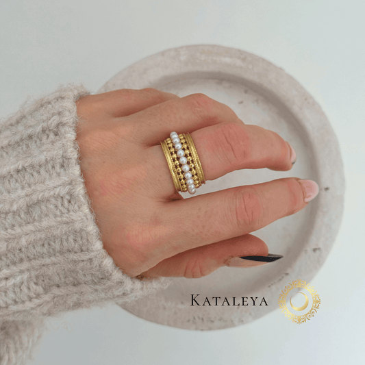 Aura Pearl Band Ring shown on a hand, featuring pearl accents and 18ct gold plated stainless steel band.