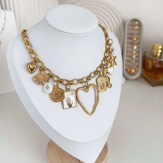 White Charm Necklace featuring a chunky gold chain with elegant white and gold charms.