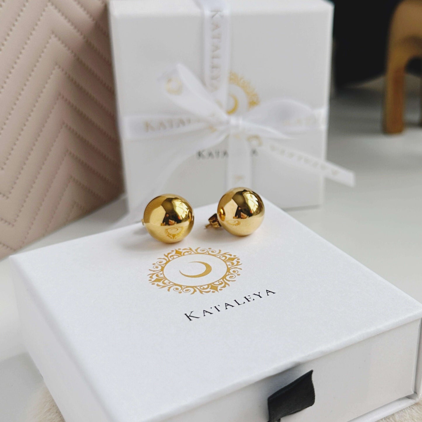 Elegant gold ball stud earrings displayed in a luxurious white gift box, perfect for sophisticated style.