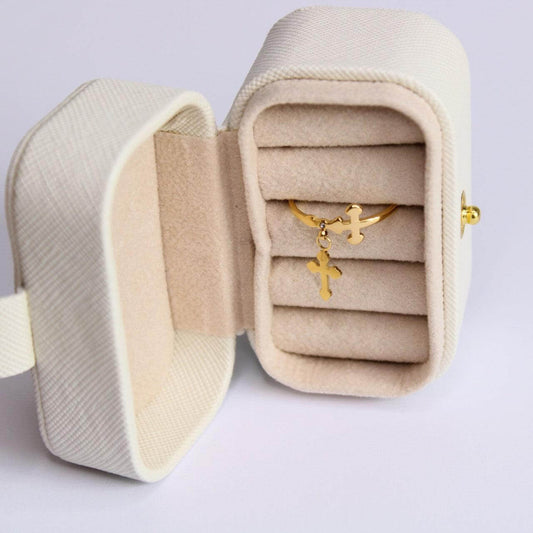 Gold-plated cross pendant ring displayed inside a luxurious beige jewelry box.