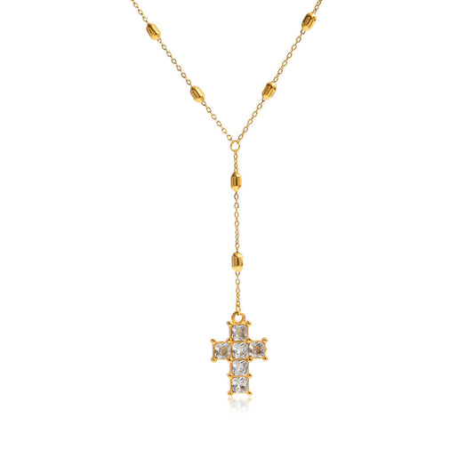 Veyra Cross Lariat Necklace showcasing a gold chain with a sparkling zircon cross drop, elegant and timeless.