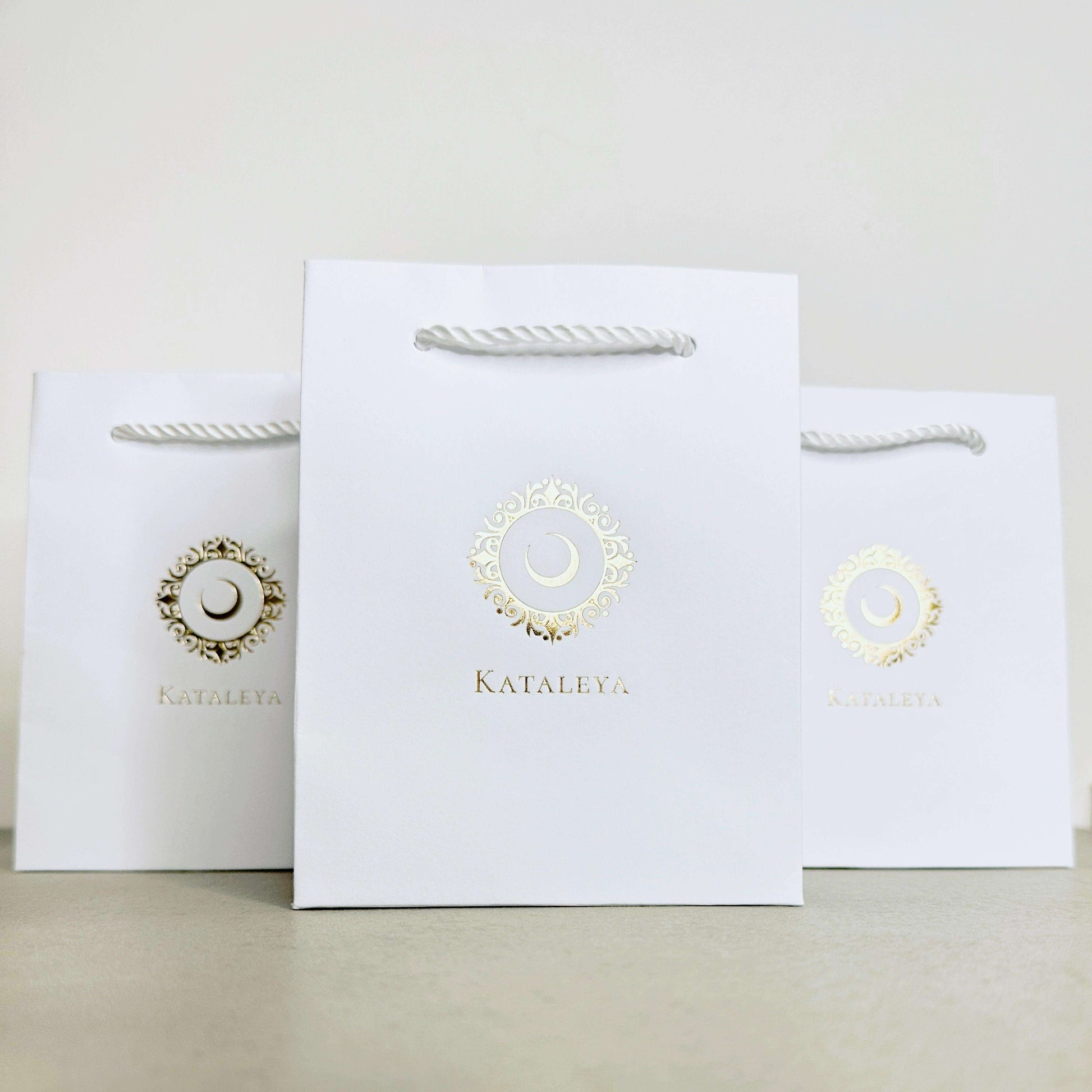 Kataleya small gift bags made from high-quality white kraft paper with elegant twisted cord handles.