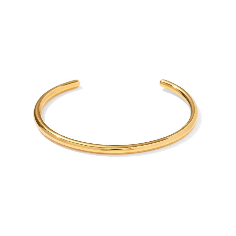 Gold open bangle in polished 18k gold plated stainless steel, featuring a chunky, minimalistic oval design.