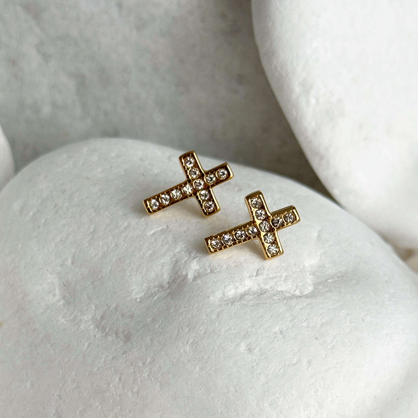 Gold plated cross zirconia studs on white stones, featuring sparkling cubic zirconia, perfect for adding elegance to any outfit.