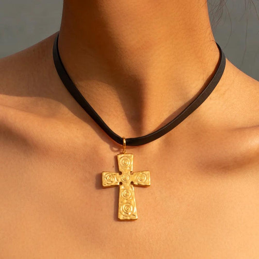 Black leather choker necklace with gold cross pendant, perfect for stylish statement jewelry.