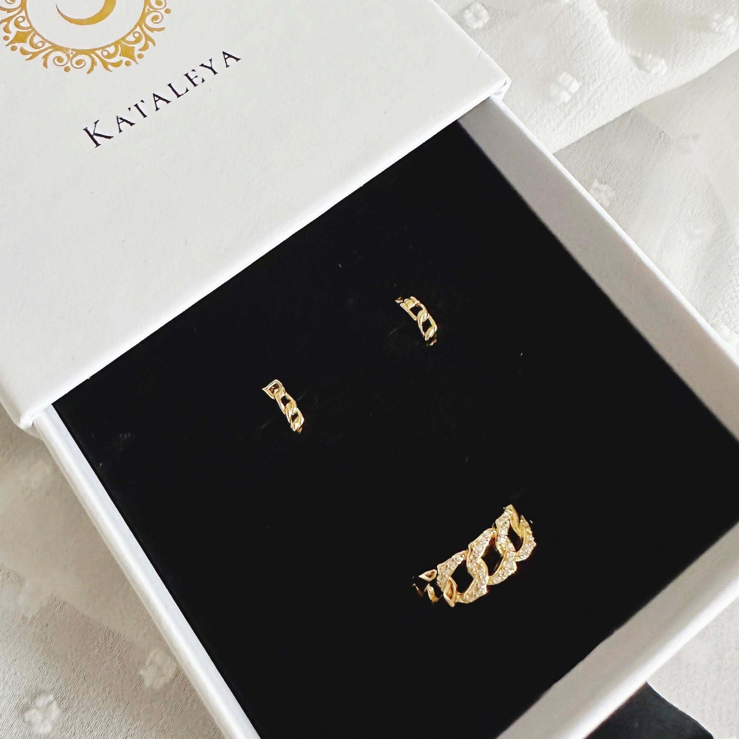 Simona Gold Jewellery Set displayed in a box, featuring gold-plated chain huggies and an adjustable chain ring.