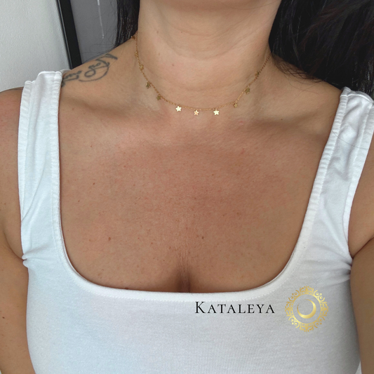 Star Charm Necklace worn on a model, featuring tiny gold star charms on a delicate chain.