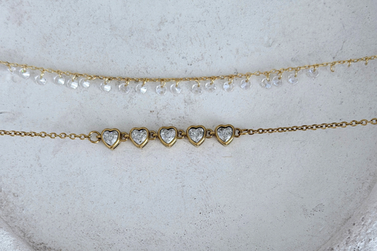 Seraphine Aurora necklace in gold plated sterling silver above the Heart Tennis Chain Necklace in gold plated stainless steel