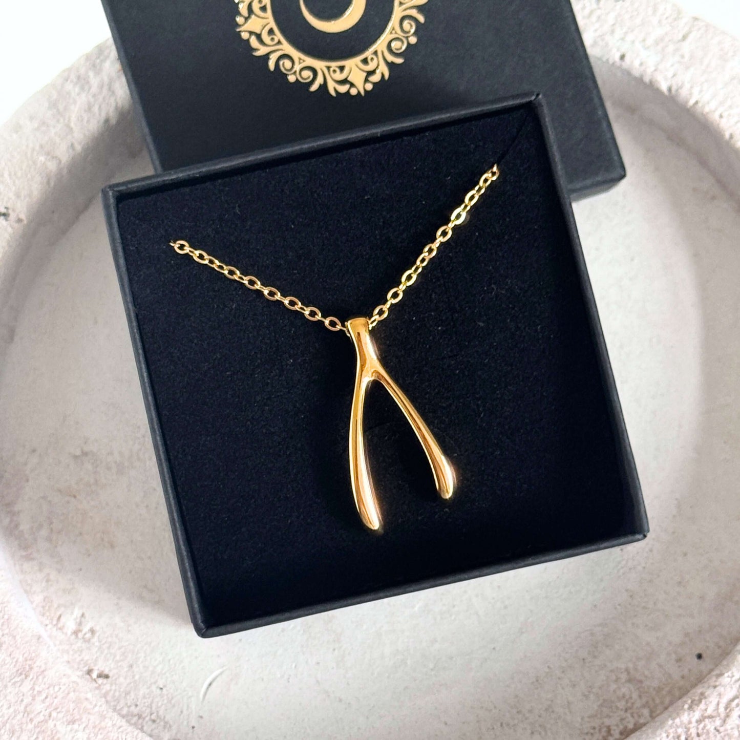 Gold Wishbone Pendant Necklace showcased in a gift box, highlighting its polished and minimal design.