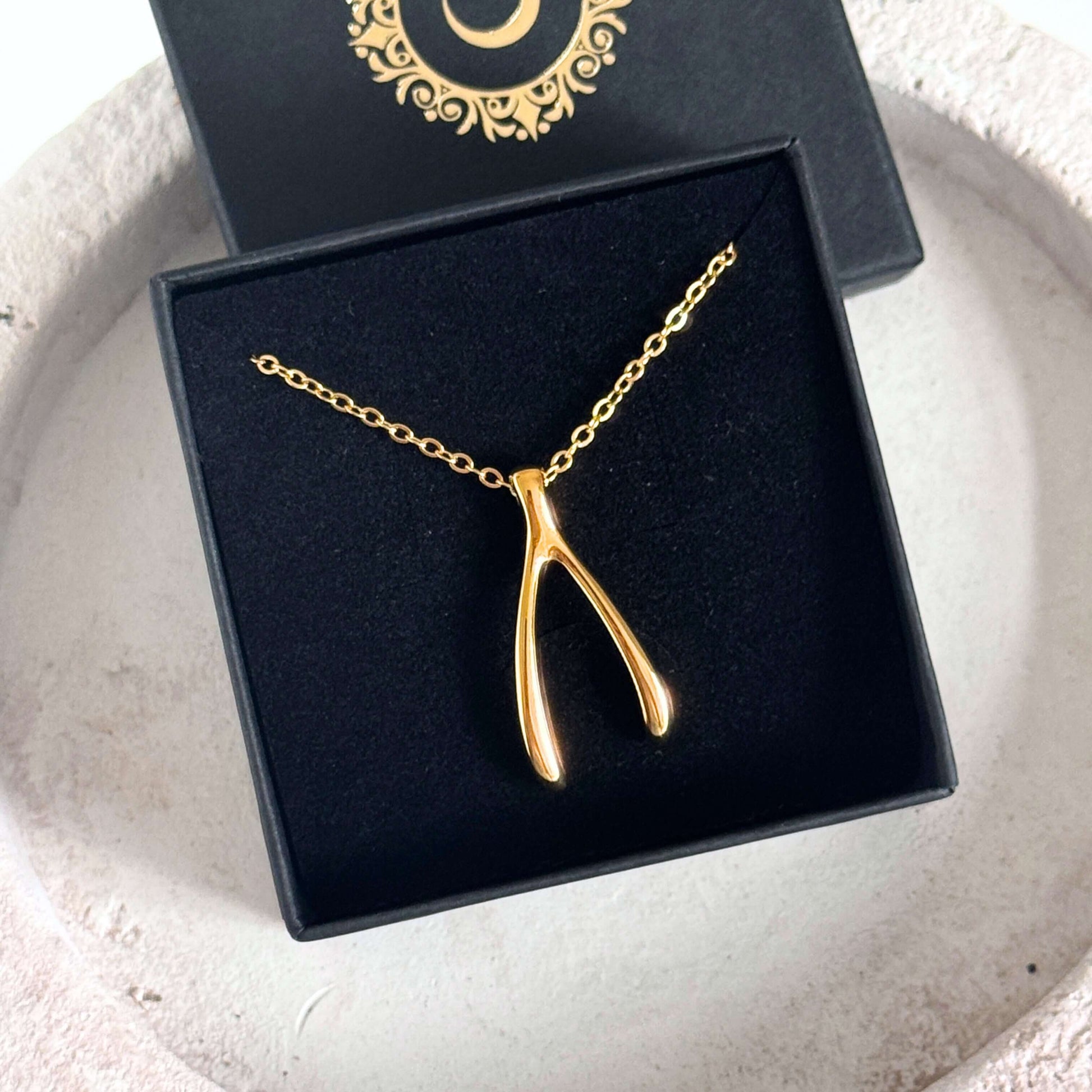 Gold Wishbone Pendant Necklace showcased in a gift box, highlighting its polished and minimal design.