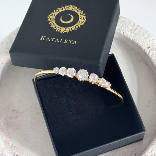 Crystal Line Bangle displayed in a black box with gold logo, featuring zirconia stones for subtle elegance.