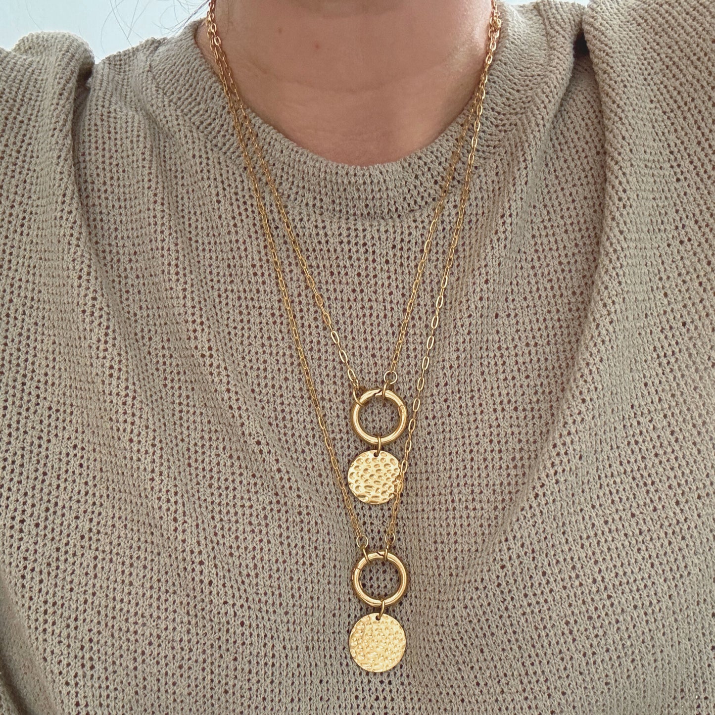 Coin Carabiner Necklace showcasing layered gold PVD stainless steel chains with textured coin pendants.