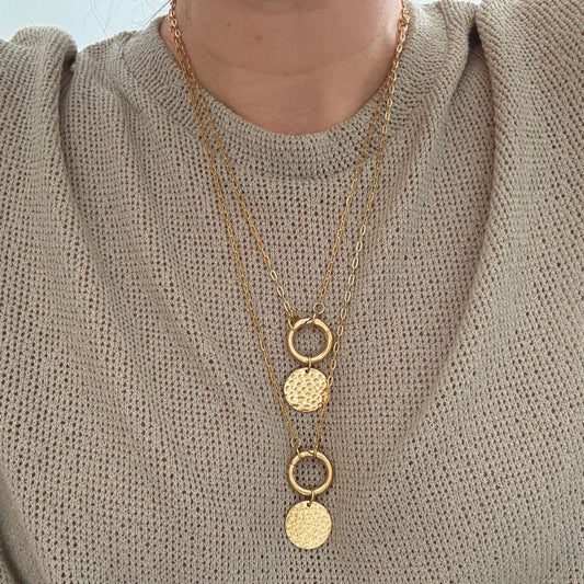 Coin Carabiner Necklace showcasing layered gold PVD stainless steel chains with textured coin pendants.