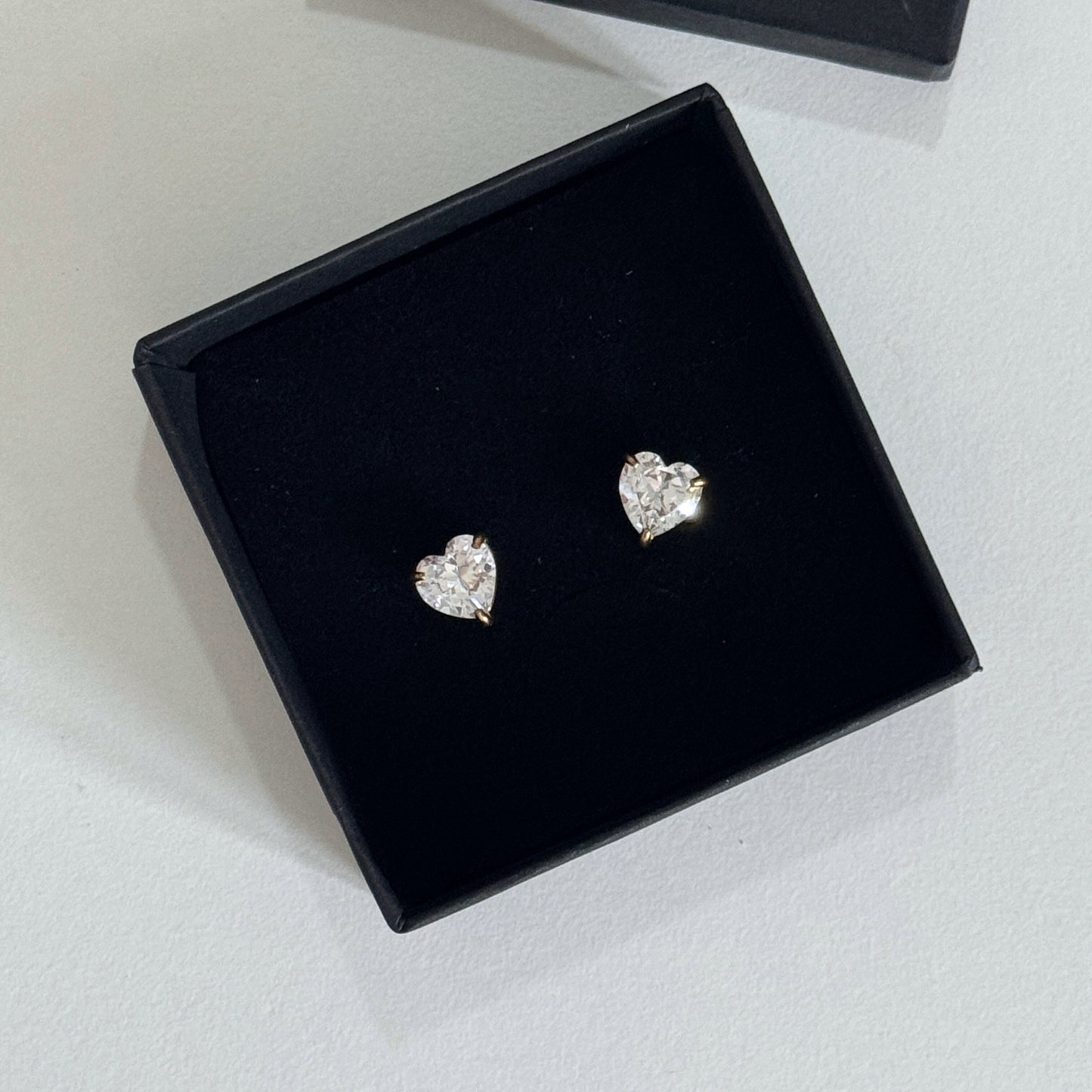 Heart stud earrings with cubic zirconia displayed in a black gift box, showcasing their elegant design.
