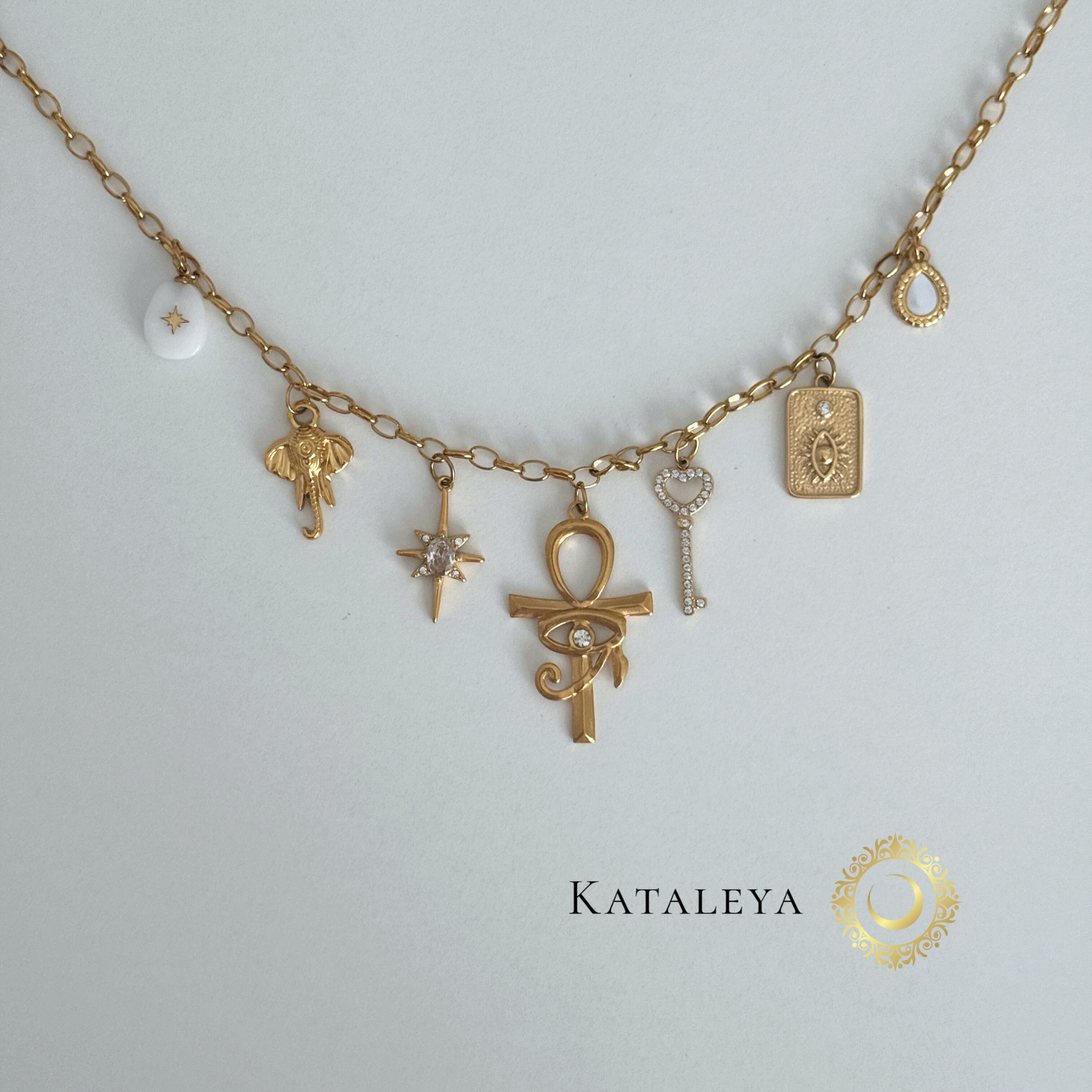 Ankh Goddess Necklace featuring gold charms including a large ankh, elephant, star, and sparkling key on a delicate chain.