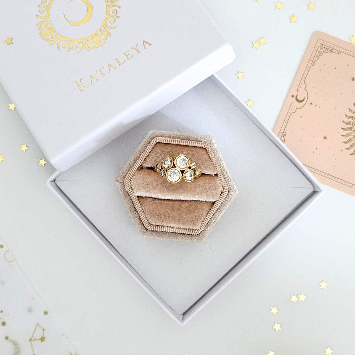 Astra Cluster Ring displayed in a stylish hexagonal box, featuring cubic zirconia set in gold.