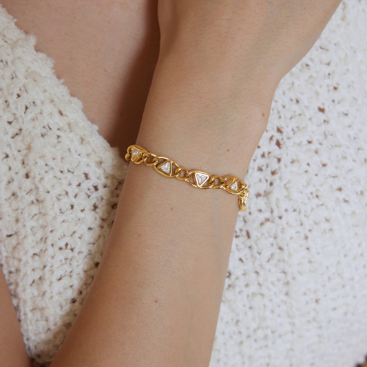 Delphi Crystal Bracelet featuring a chunky gold chain and cubic zirconia triangles on a wrist.