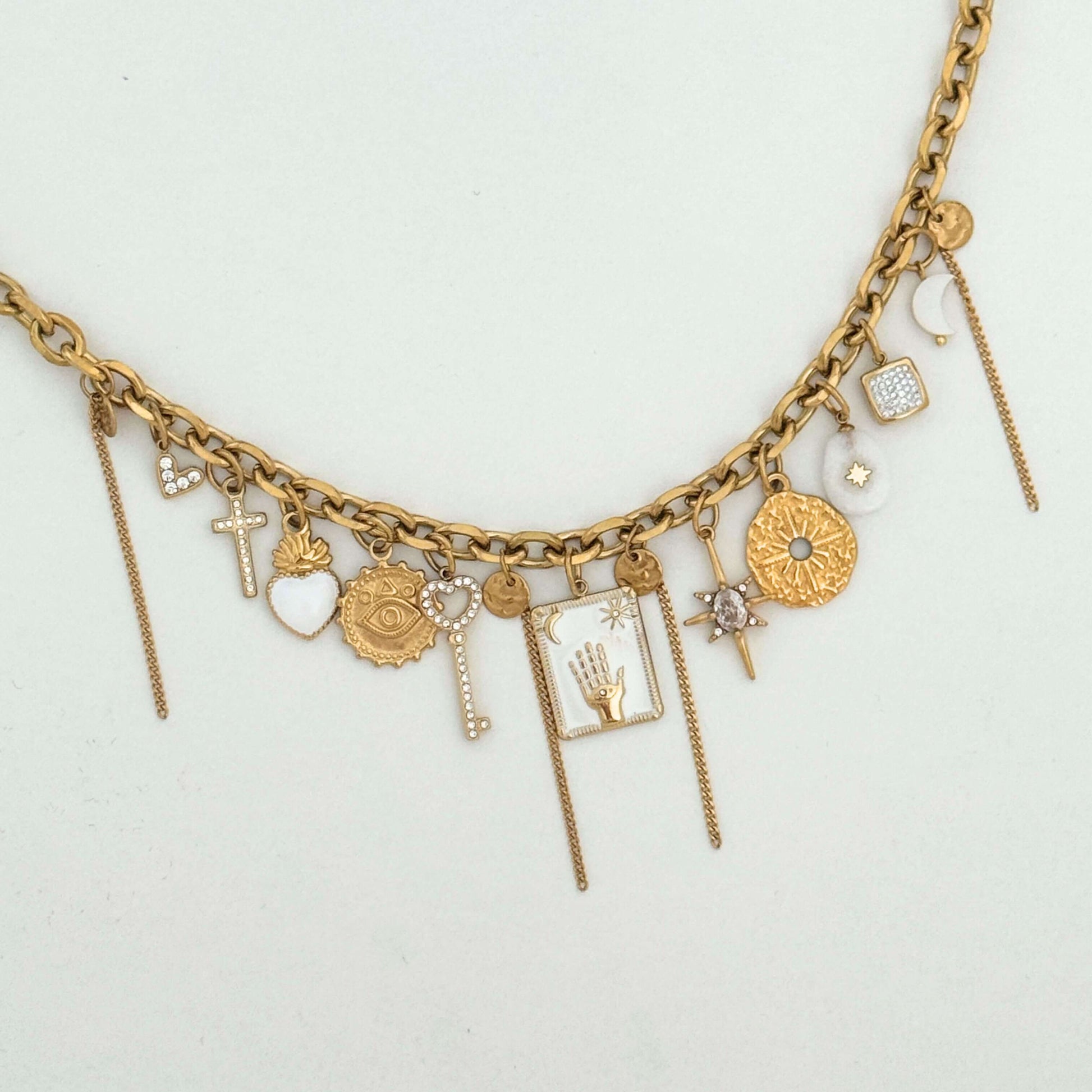 Gold & white multi charm necklace on a light gray background by Kataleya Jewellery