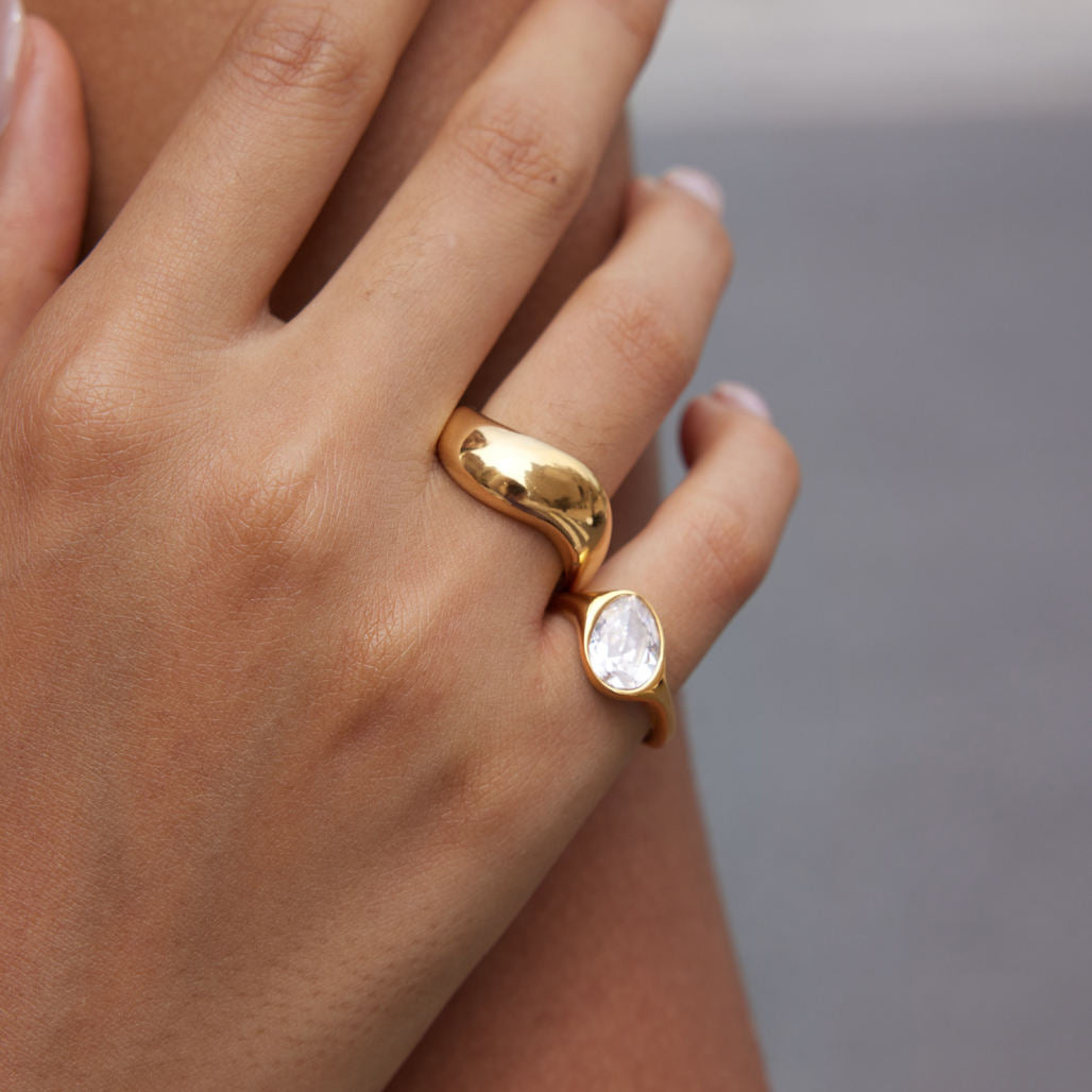 Close-up of a hand wearing the Elara Pinky Ring with a cubic zirconia set in gold.