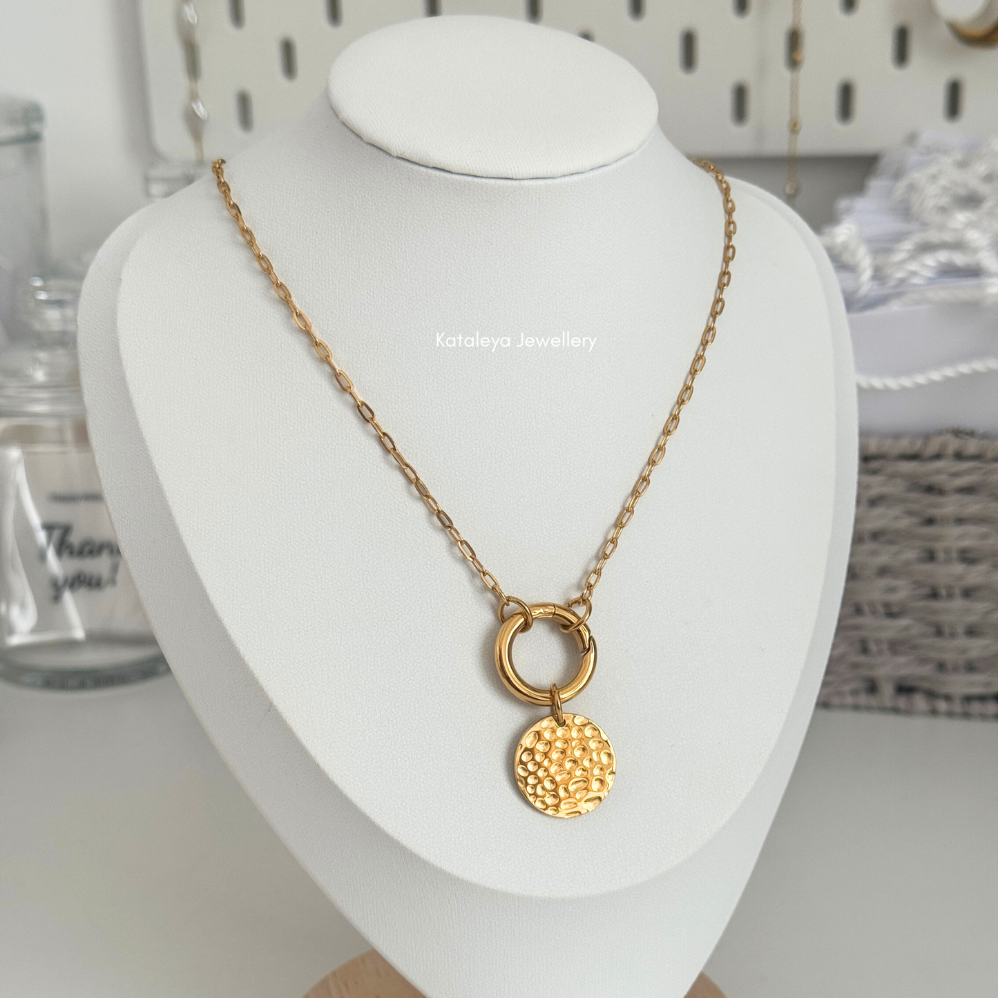 Coin Carabiner Necklace – Gold PVD Stainless Steel displayed on a jewelry stand.