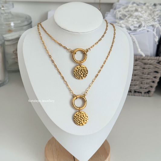 Coin Carabiner Necklace – Gold PVD Stainless Steel displayed on a necklace stand with textured coin pendant.