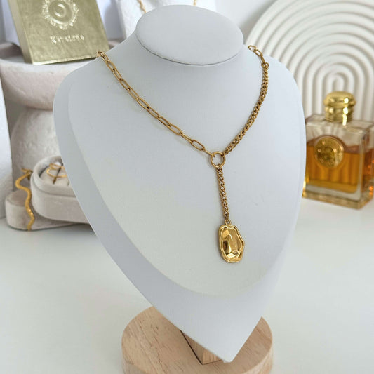 Gold lariat necklace with a molten pendant on a white mannequin bust by Kataleya Jewellery