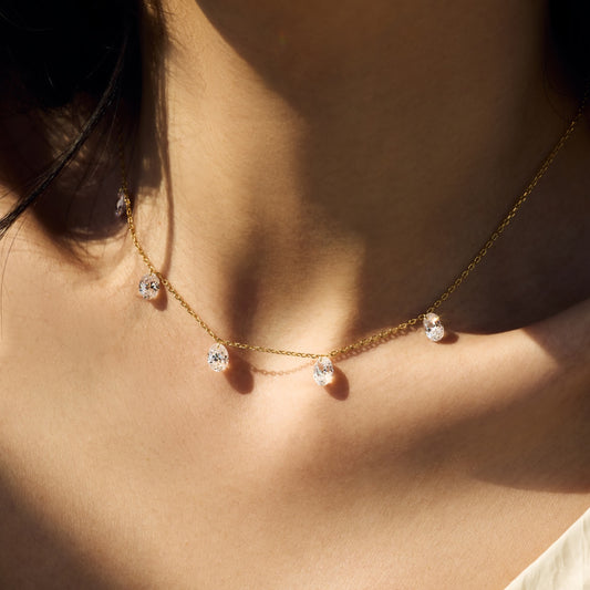 Gold Seraphine Radiance necklace with diamond pendants on a person's neck by Kataleya Jewellery