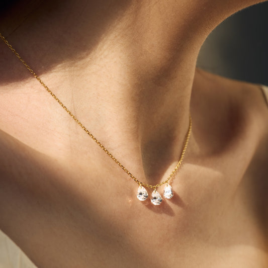 Gold Seraphine Trinity necklace with three droplet pendants on a person's neck - Kataleya Jewellery