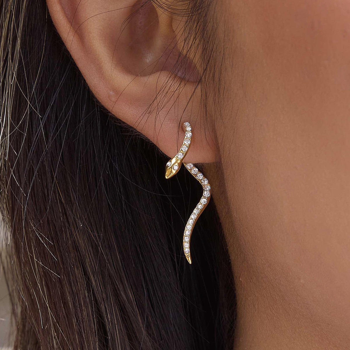 Ophira Serpent Earrings featuring a gold serpent design with crystal pavé set, elegantly curving on the ear.