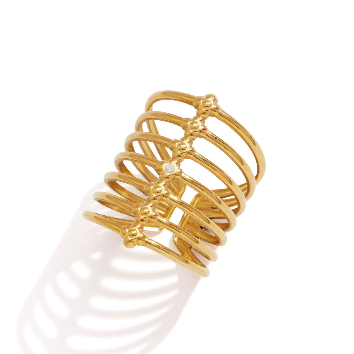 Orla Cage Ring featuring fine gold bands and a cubic zirconia at the center, creating a layered ring look.