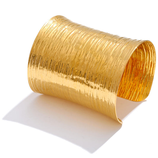 Theia Wide Cuff in gold with a textured surface, 7.5cm long, designed to catch the light beautifully.