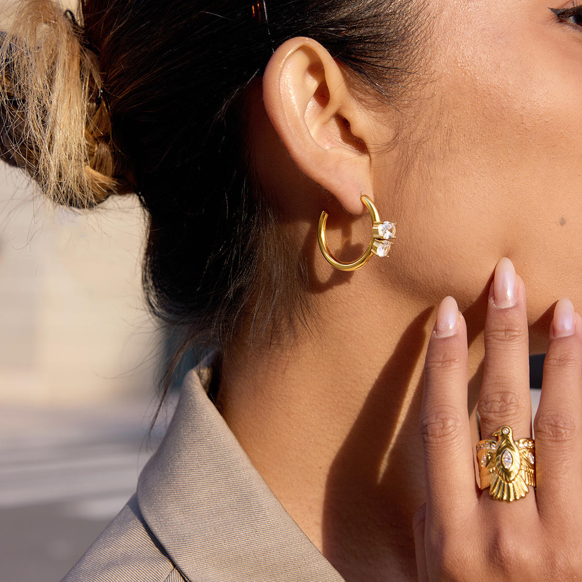 Model wearing Vega Crystal Hoops, showcasing elegant design with crystal accents and gold plated stainless steel.