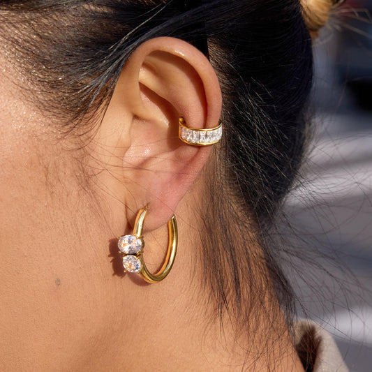 Close-up of wearing Vega Crystal Hoops, gold plated stainless steel earrings with crystals catching light.