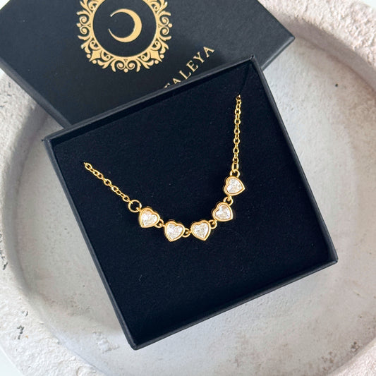 Heart Tennis Chain Necklace showcasing five heart-shaped cubic zirconia stones in a gold setting.