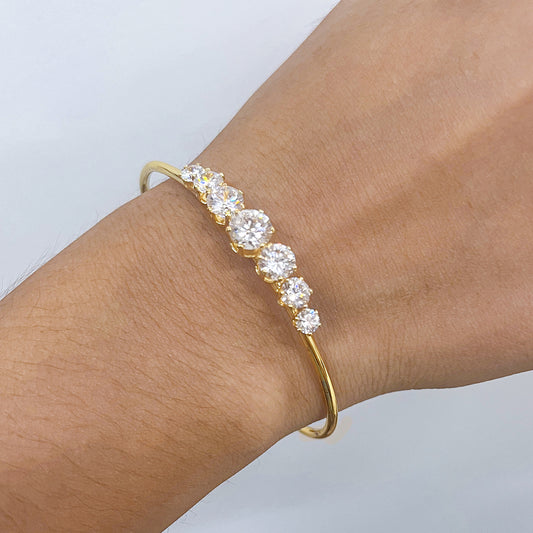 Crystal Line Bangle featuring a sleek design and high-clarity zirconia stones glimmering on a gold band.